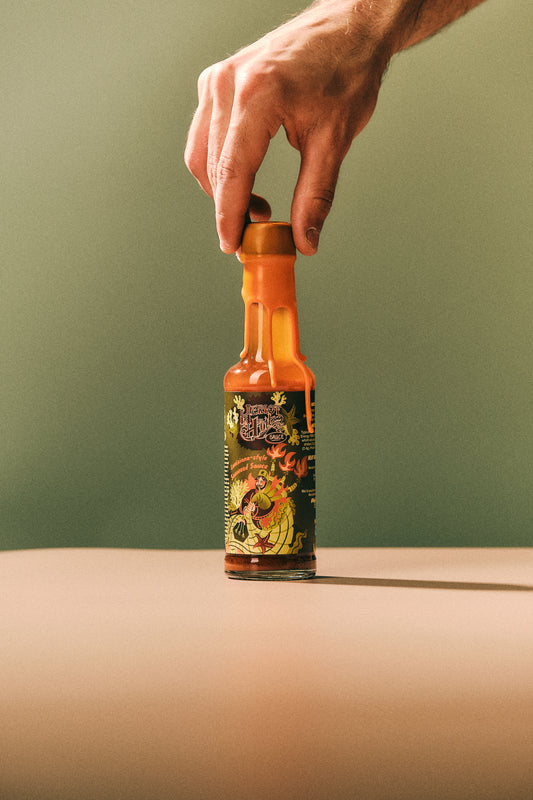 Hand Placing Lousiana-Style Seaweed Hott Sauce in frame - Heriot Hott